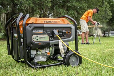 image of a Portable Generac Generator in an Ohio backyard while a man wood works.